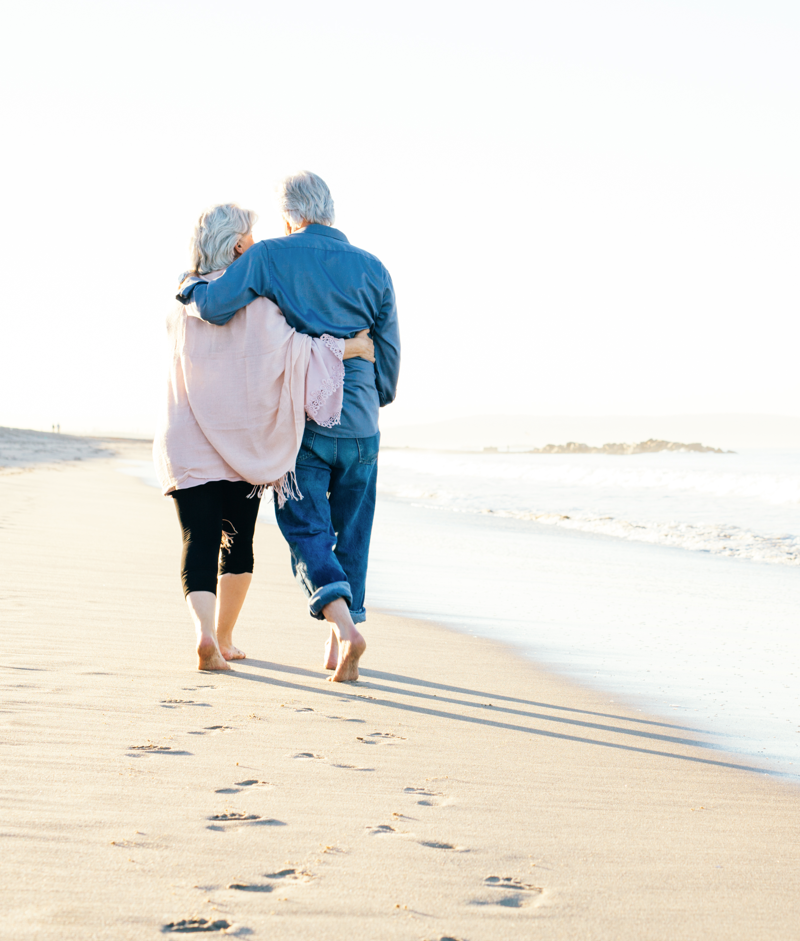 Retired couple walking on the beach