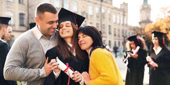 college parents hugging their graduate